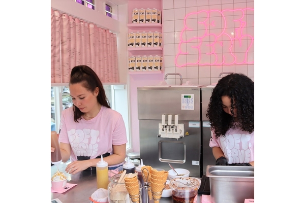 Two women at the Oatly pop-up in Amsterdam putting toppings on ice cream.